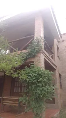 a brick building with a tree in front of it at Cabañas El Molinillo in Nono