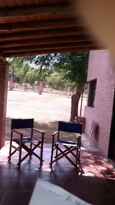 two chairs sitting on a porch with a view of a field at Cabañas El Molinillo in Nono