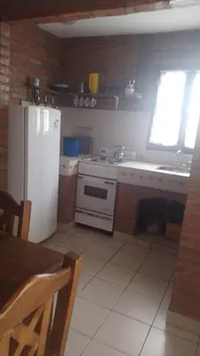 a kitchen with a white refrigerator and a sink at Cabañas El Molinillo in Nono