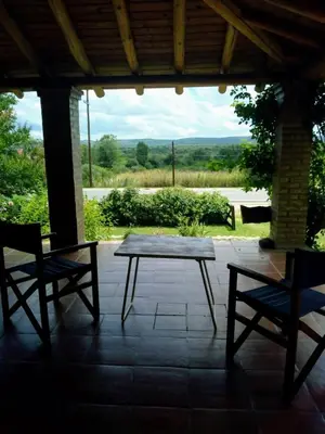 a wooden table and two chairs on a patio at Cabañas El Molinillo in Nono