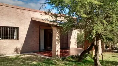 a brick building with a door and a tree at Cabañas El Molinillo in Nono