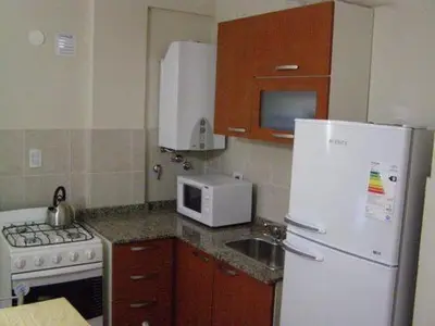 a kitchen with a white refrigerator and a microwave at Apartamento Edificio Atlantis I in Villa Carlos Paz