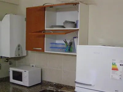a kitchen with a white microwave and a refrigerator at Apartamento Edificio Atlantis I in Villa Carlos Paz