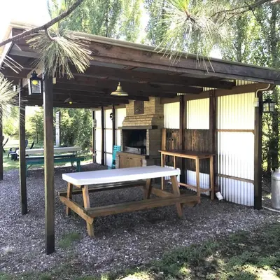 a picnic shelter with a picnic table and a grill at Refugio Del Guira Guira in Los Reartes
