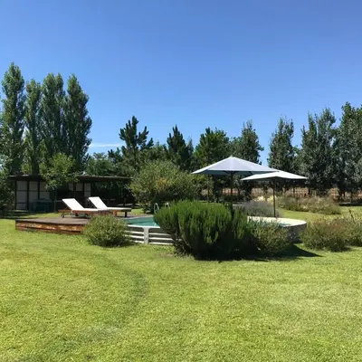 a backyard with a pool and umbrellas at Refugio Del Guira Guira in Los Reartes