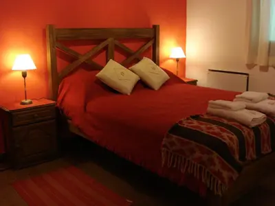 a bedroom with a red bed with towels on it at Las Acacias - Posada de Campo in Villa General Belgrano