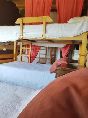 two bunk beds in a room with red curtains at Tierra Sagrada Eco Lodge in La Población