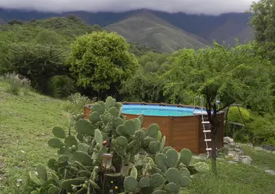 a swimming pool in a garden with a cactus at Tierra Sagrada Eco Lodge in La Población