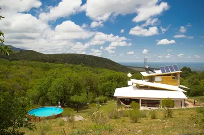 a house with solar panels on top of a hill at Tierra Sagrada Eco Lodge in La Población