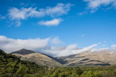 a view of a mountain range with clouds in the sky at Tierra Sagrada Eco Lodge in La Población