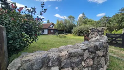 a stone wall in front of a house at Cabaña Odanak in Villa General Belgrano