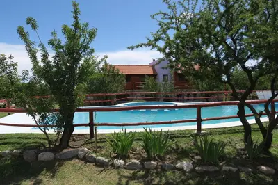 a swimming pool in a yard with trees at Cabañas Yanasuy in Merlo