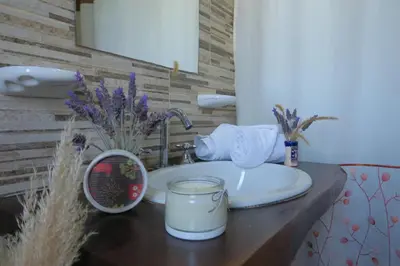 a bathroom sink with a candle on a counter at Cabañas Yanasuy in Merlo