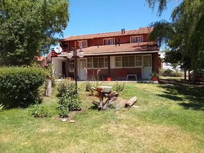 a house with a garden in front of it at Complejo Viejo Sulky in Mina Clavero