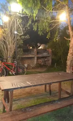 a wooden bench in a park with a bike at Complejo Viejo Sulky in Mina Clavero