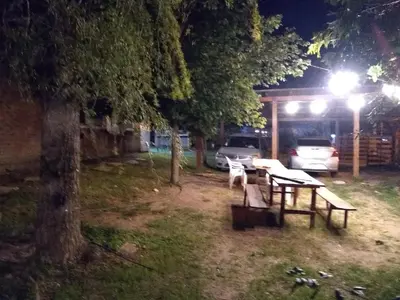a picnic table and benches in a yard at night at Complejo Viejo Sulky in Mina Clavero