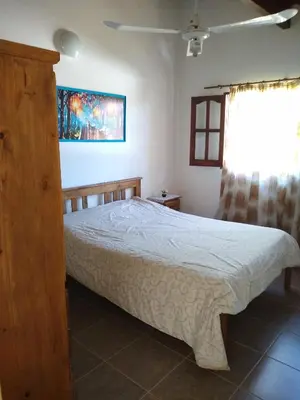 a bedroom with a bed and a window at Complejo Viejo Sulky in Mina Clavero