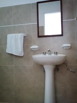 a bathroom with a sink and a mirror at El Camino Hostel in Mina Clavero