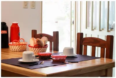 a table with cups and saucers on top of it at El Camino Hostel in Mina Clavero