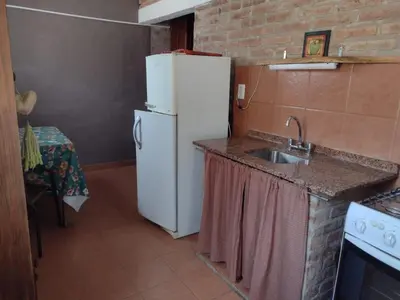 a kitchen with a white refrigerator and a sink at Cabañas Nueve Lunas in Santa Rosa de Calamuchita