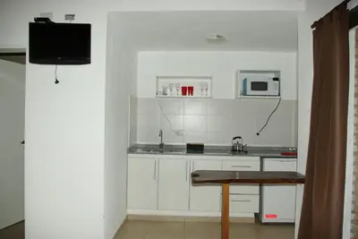 a white kitchen with a sink and a microwave at Amaikén Suites in Nono