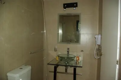 a bathroom with a sink and a mirror and a toilet at Amaikén Suites in Nono