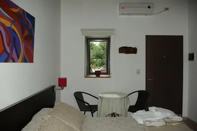 a bedroom with a bed and a table and a window at Amaikén Suites in Nono