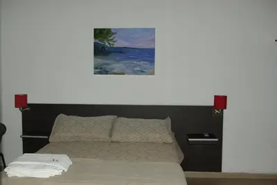 a bedroom with a bed with a painting above it at Amaikén Suites in Nono