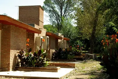 a brick house with flowers in a garden at Amaikén Suites in Nono