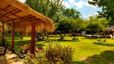 a pavilion with a grass roof in a garden at Amaikén Suites in Nono