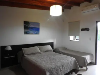 a bedroom with a bed and a window and a lamp at Amaikén Suites in Nono
