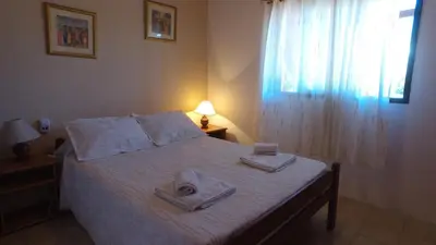 a bedroom with a bed with two towels on it at Hosteria Nilo Azul in Mina Clavero