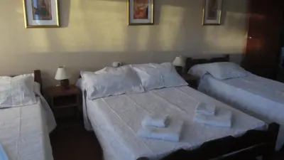 two beds in a bedroom with towels on them at Hosteria Nilo Azul in Mina Clavero