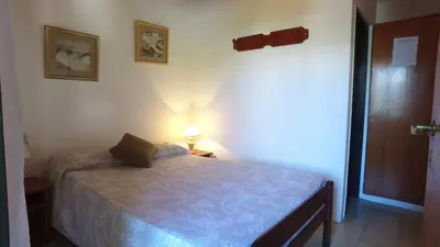 a small bedroom with a bed and a lamp at Hosteria Nilo Azul in Mina Clavero