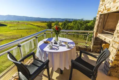 a table with a vase of flowers on a balcony at Blackstone Country Villages Hotel in Villa General Belgrano