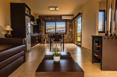 a kitchen and living room with a table and a couch at Blackstone Country Villages Hotel in Villa General Belgrano