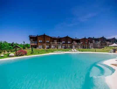 a large swimming pool in front of a house at Blackstone Country Villages Hotel in Villa General Belgrano