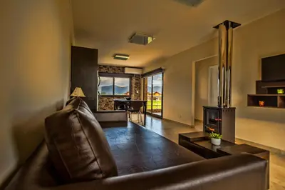 a living room with a leather couch and a table at Blackstone Country Villages Hotel in Villa General Belgrano