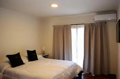 a bedroom with a large bed and a window at Blackstone Country Villages Hotel in Villa General Belgrano