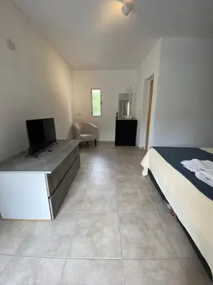 a bedroom with a bed and a tv in it at Complejo El Faro in Santa Rosa de Calamuchita