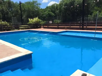 a large blue swimming pool with blue water at Complejo El Faro in Santa Rosa de Calamuchita