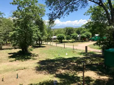 a park with trees and a dirt road at Complejo El Faro in Santa Rosa de Calamuchita