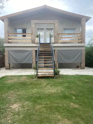 a house with a staircase in front of it at Complejo El Faro in Santa Rosa de Calamuchita