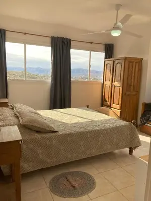 a bedroom with a bed with a large window at Cabañas del Rey in Villa Carlos Paz