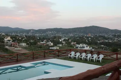 a group of chairs sitting next to a swimming pool at Cabañas del Rey in Villa Carlos Paz