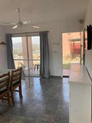 a kitchen with a table and chairs and a large window at Cabañas del Rey in Villa Carlos Paz