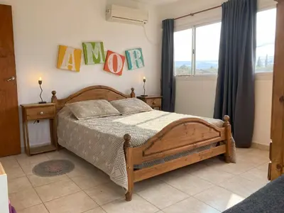 a bedroom with a wooden bed and a window at Cabañas del Rey in Villa Carlos Paz