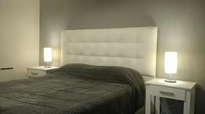 a bedroom with a bed and two lights on tables at Nueva Córdoba Rondeau in Cordoba