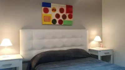 a bedroom with a bed and two tables with lamps at Nueva Córdoba Rondeau in Cordoba