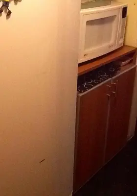 a kitchen with a microwave on top of a refrigerator at Nueva Córdoba Rondeau in Cordoba